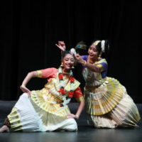 Two mohiniyattam dancers as Yashoda and Krishna in traditional white costumes