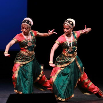 Two bharathanatyam dancers in green and red in agressive poses